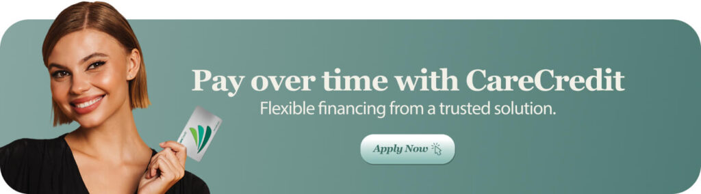 Person smiling and holding a CareCredit card in front of a green background with text promoting flexible financing.