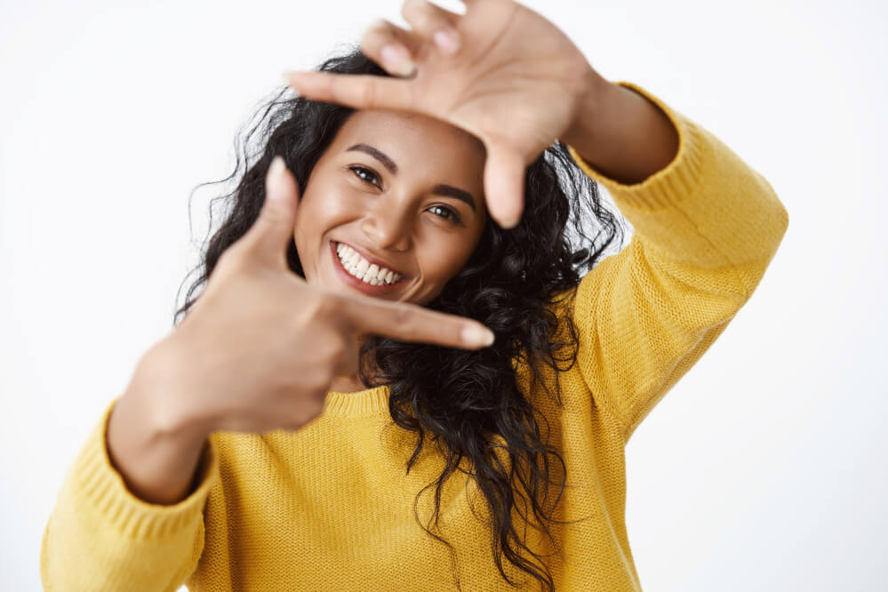 Girl smiling happily after having her teeth repaired using a dental bridge